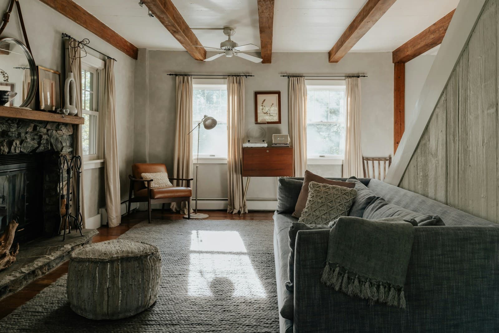Living room with warm neutral walls, exposed timber beams and soft window light