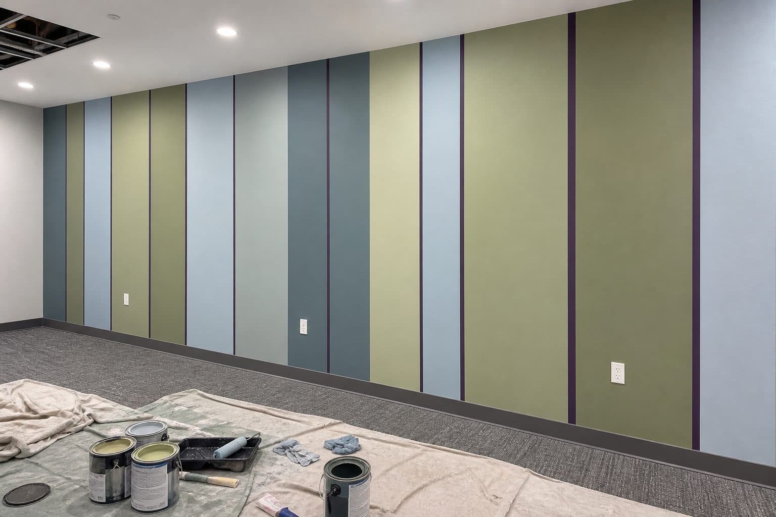 Polygon stripe feature wall with protected flooring and painting tools during the work